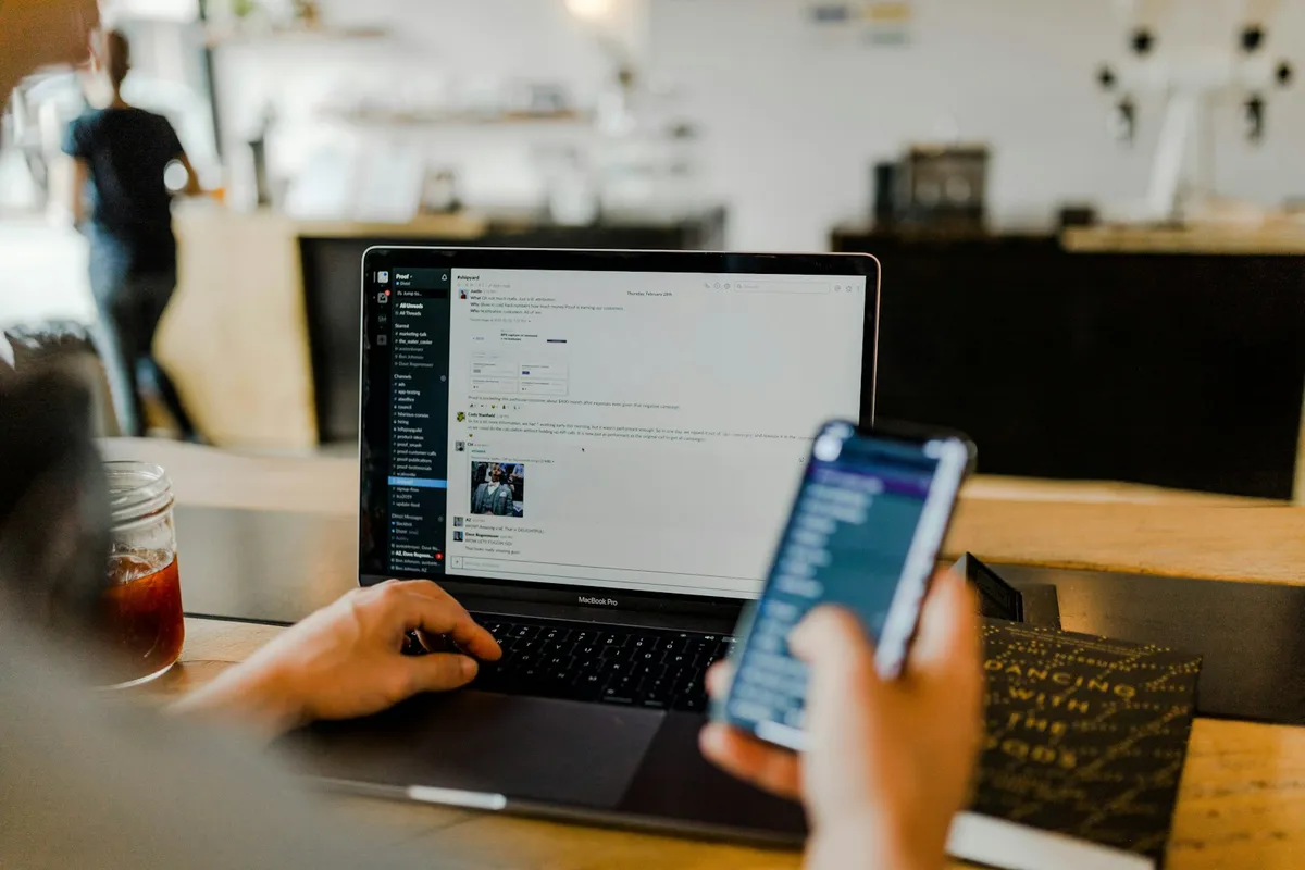 Person with a laptop and phone in a cafe
