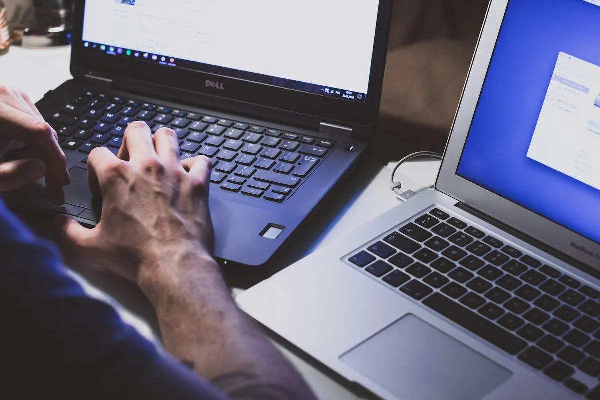 Hands typing on a laptop